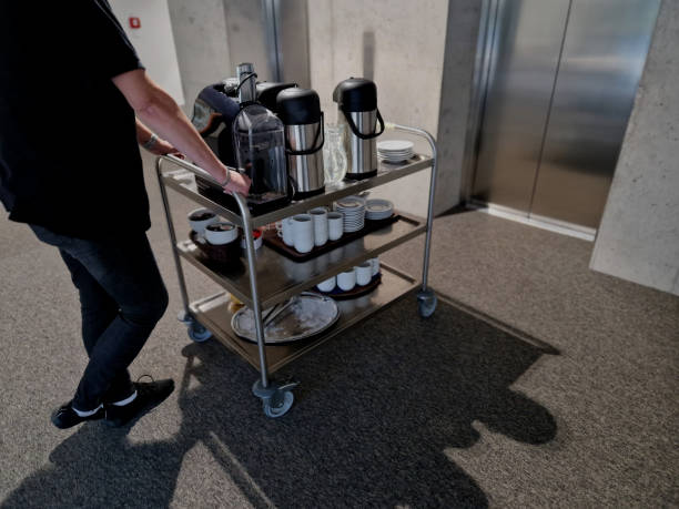 istock the serving cart delivers refreshments to the office coffee and tableware must not be missing at any corporate meeting. stainless steel lift, the door is driven by a hotel waitress 1876570844