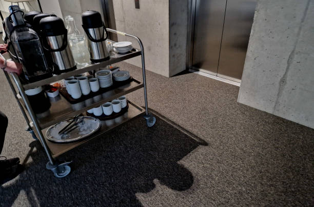istock the serving cart delivers refreshments to the office coffee and tableware must not be missing at any corporate meeting. stainless steel lift, the door is driven by a hotel waitress 1876570845