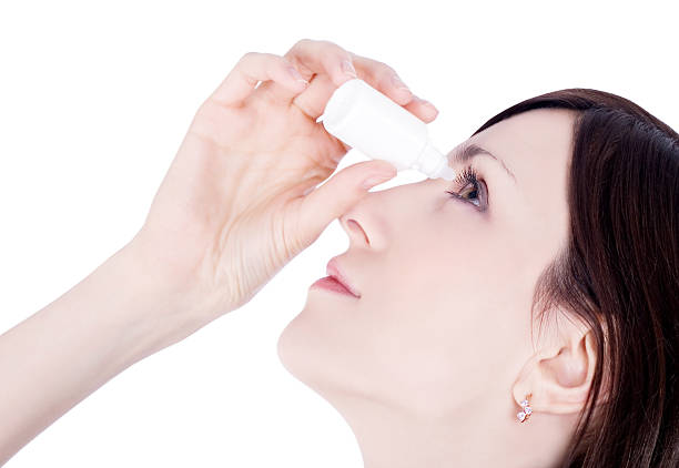 woman dripping eye with eyes drops woman dripping eye with eyes drops saline drip stock pictures, royalty-free photos & images