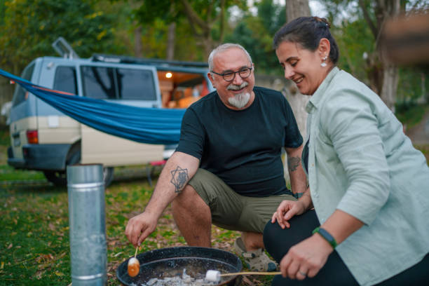 Couple grilling marshmallows on the barbecue.