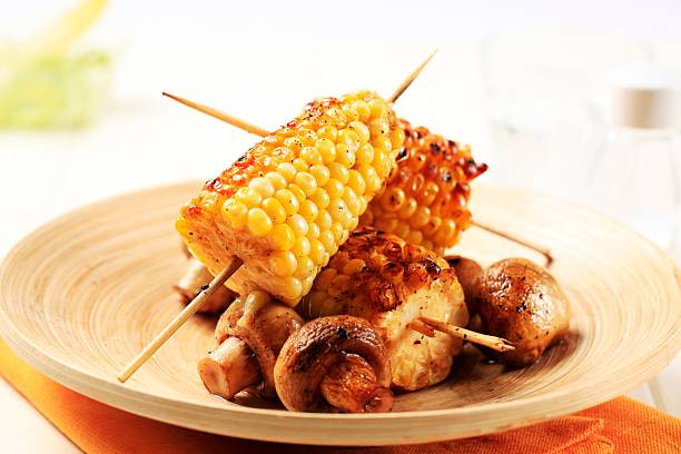 Grilled sweet corn cobs and button mushrooms