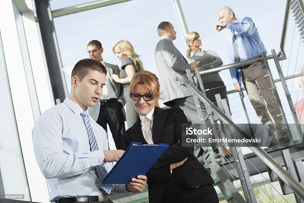 Zwei Arbeiter im Büro mit Kollegen im Hintergrund - Lizenzfrei Arbeiten Stock-Foto
