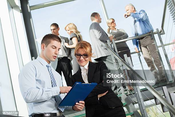 Zwei Arbeiter Im Büro Mit Kollegen Im Hintergrund Stockfoto und mehr Bilder von Arbeiten - Arbeiten, Bürojob, Dokument