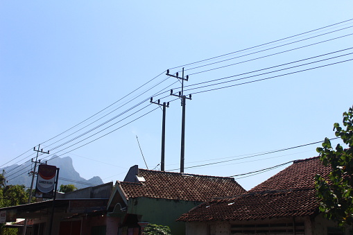 Two electricity poles are attached to the top of the house