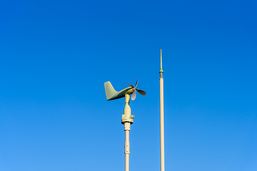 Wind direction plane on blue sky background, energy conservation concept.