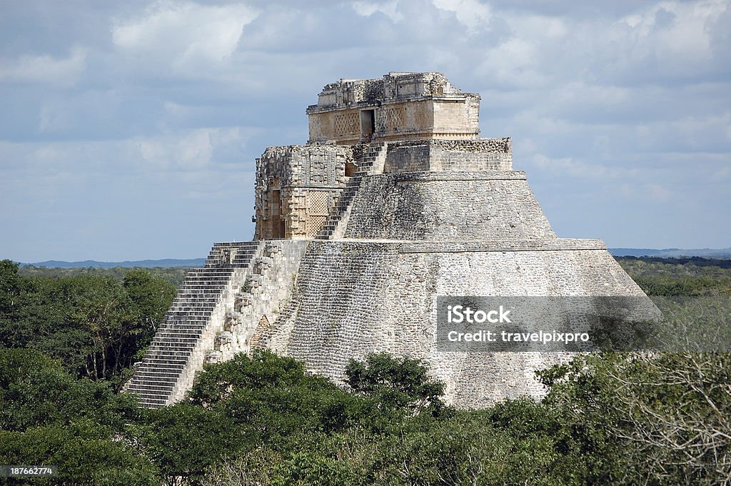 Uxmal Pyramid of the Magician on Yucatan Peninsula Mexico Pyramid of the Magician rising above the forest at Uxmal Archeological Site in the Puuc Region of the Yucatan Peninsula near Merida, Mexico. Merida - Mexico Stock Photo