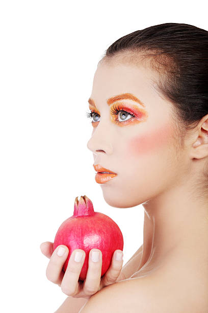 istock Attractive woman with orange make up and pomengraate. 187664559