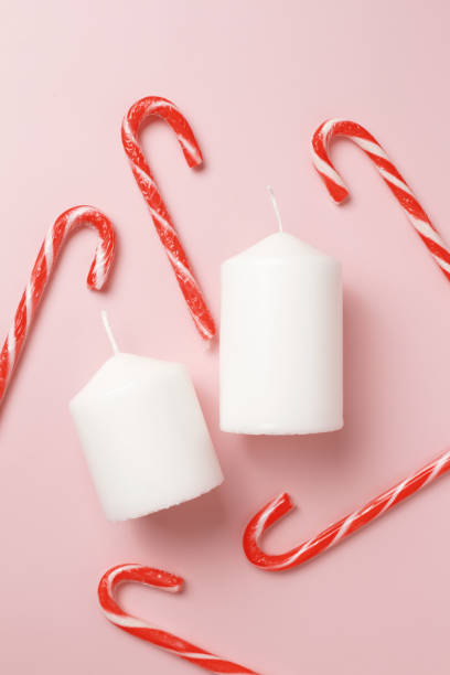istock Decorative Christmas composition from candles, candy canes, isolated on pink background 1876649461