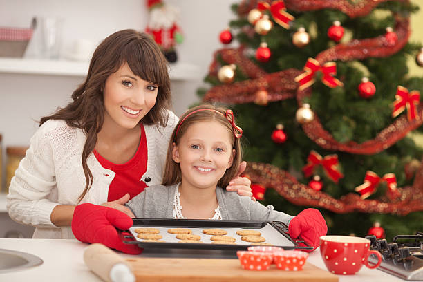 istock Mother and daughter with cookies by christmas tree. 187666823