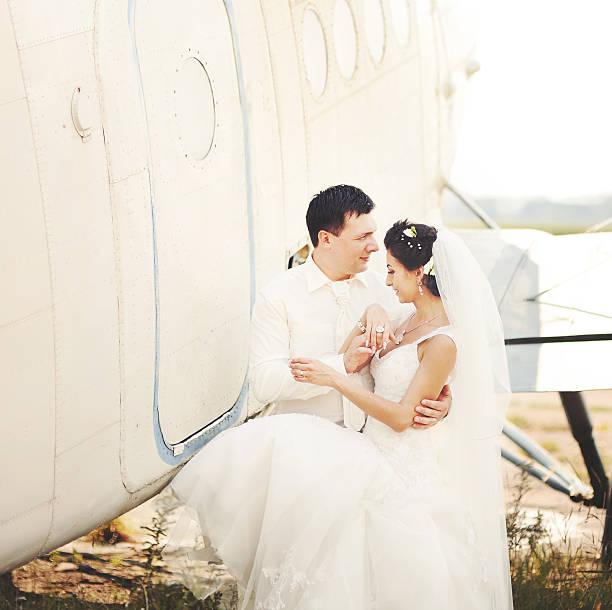 istock young caucasian wedding couple next to airplane 187671092