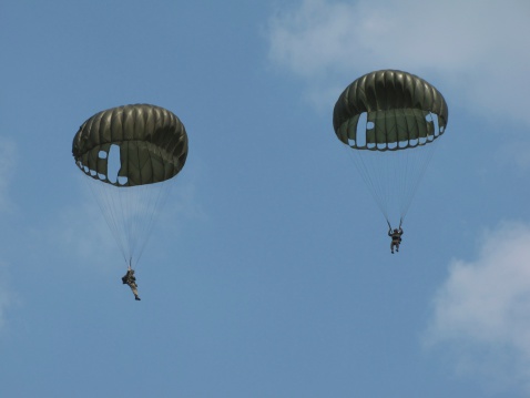 Two parachutists floating to the ground with second world war gear