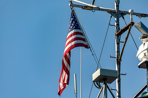 The great American flag, flying on the flagpole of an American ship, from where it is sighted informing of its nationality.
