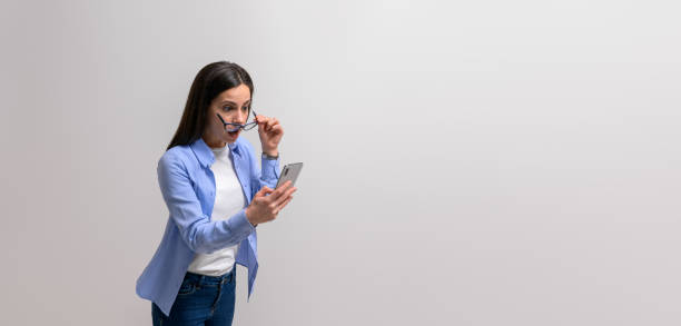 istock Anxious freelancer holding glasses and reading unexpected message on cellphone over white background 1876723739