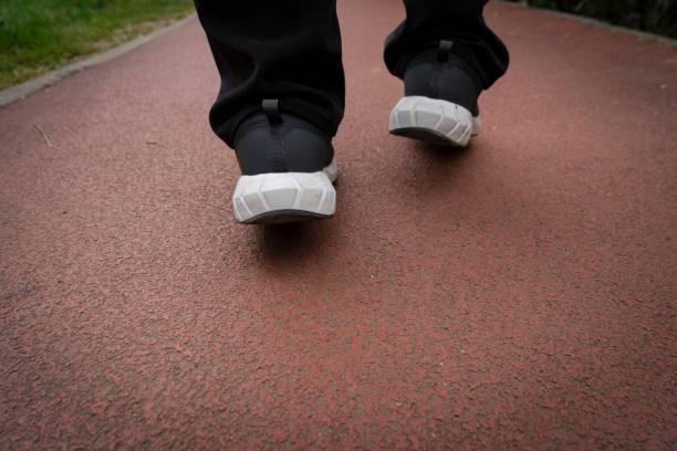 Man in sneakers on red athletic running track, close up