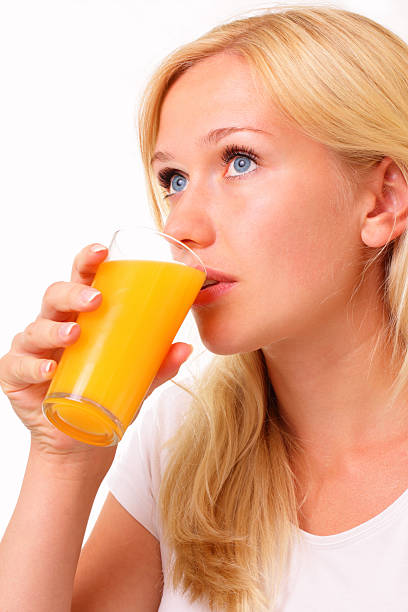 Beautiful young woman drinking juice stock photo