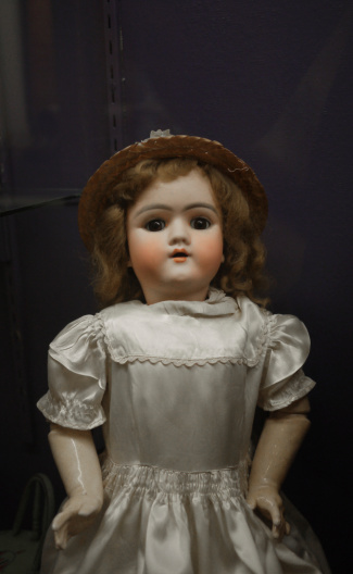 Old doll with white dress and hat