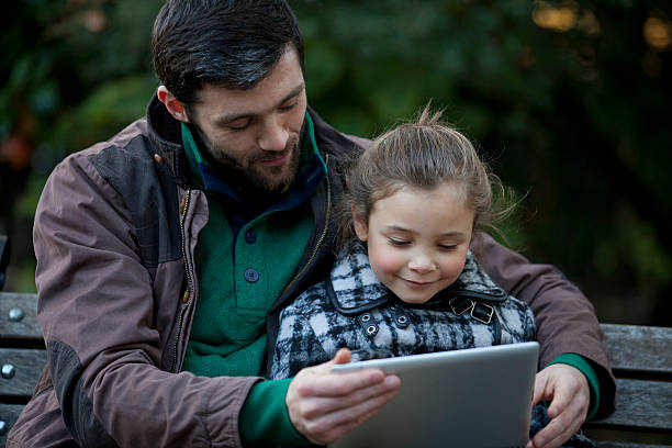 istock Father and daughter in the park with a tablet 187676575
