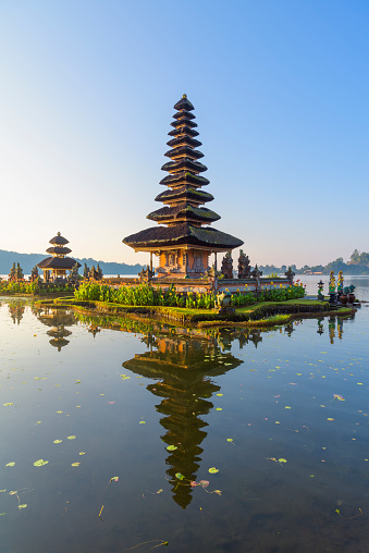 Pura Ulun Danu Beratan, or Pura Bratan, is a major Hindu Shaivite temple in Bali. The temple complex is on the shores of Lake Bratan in the mountains near Bedugul.
In Bali, Hindu temples are known as pura, being designed as open-air places of worship in walled compounds. The shrines are known as merus and are square structures with brick bases and multiple pagoda-style thatched roofs; the number of roofs reflects the status of the deity, and is always an odd number. The temple complex consists of five various shrines dedicated to other Hindu gods as well.
Built in 1633, the temple is used for offerings and ceremonies dedicated to the Balinese water, lake and river goddess Dewi Danu, due to the importance of Lake Bratan as a main source of irrigation in central Bali. The 11-storey pelinggih meru in the complex is dedicated to Shiva and his consort Parvathi. Buddha's statue is also enshrined in this temple.
Pura Ulun Danu Beratan, Bedugul, Bali, Indonesia, Asia.