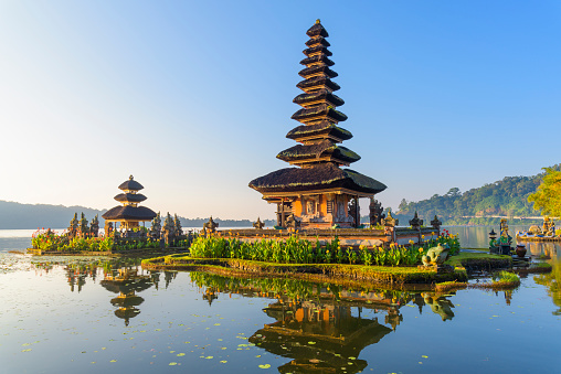 Pura Ulun Danu Beratan, or Pura Bratan, is a major Hindu Shaivite temple in Bali. The temple complex is on the shores of Lake Bratan in the mountains near Bedugul.
In Bali, Hindu temples are known as pura, being designed as open-air places of worship in walled compounds. The shrines are known as merus and are square structures with brick bases and multiple pagoda-style thatched roofs; the number of roofs reflects the status of the deity, and is always an odd number. The temple complex consists of five various shrines dedicated to other Hindu gods as well.
Built in 1633, the temple is used for offerings and ceremonies dedicated to the Balinese water, lake and river goddess Dewi Danu, due to the importance of Lake Bratan as a main source of irrigation in central Bali. The 11-storey pelinggih meru in the complex is dedicated to Shiva and his consort Parvathi. Buddha's statue is also enshrined in this temple.
Pura Ulun Danu Beratan, Bedugul, Bali, Indonesia, Asia.