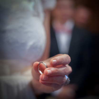 Wedding ring in the fingers of a bride in a church