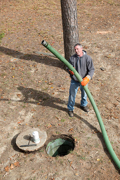 istock Septic Tank Home Improvement Worker Holds Hose 187683603