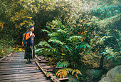 Asian Chinese young woman crossing footbridge hiking during weekend morning