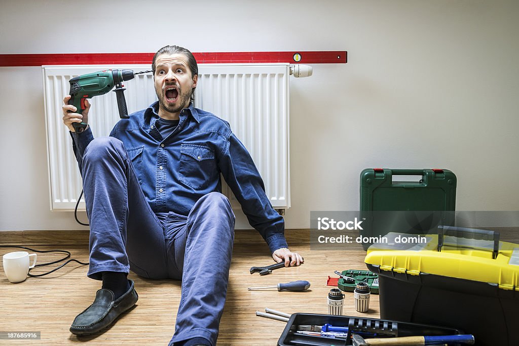 Mann Reparatur Heizung, er müde, frustriert, sitzt unter der Heizkörper - Lizenzfrei Frustration Stock-Foto