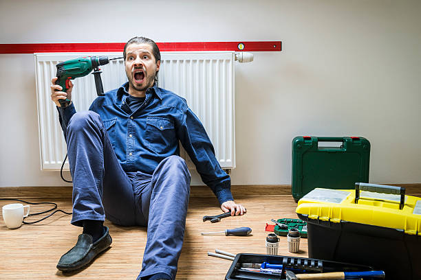 istock Man repairs heater, he's tired, frustrated, sits under the radiator 187685916