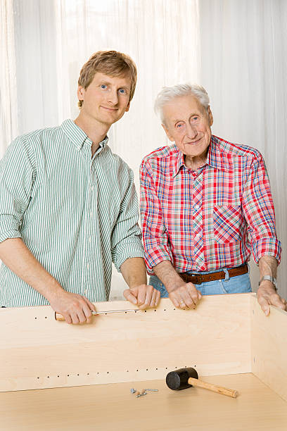 istock Collaboration: Grandfather and grandson assembling furniture 187686266