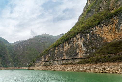 The Three Gorges of the Yangtze River are quiet and charming, with majestic peaks, clear river water and shrouded clouds. Trail on the mountain wall.