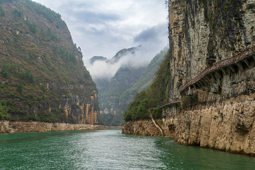 The Three Gorges of the Yangtze River are quiet and charming, with majestic peaks, clear river water and shrouded clouds. Trail on the mountain wall.