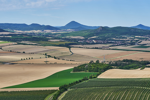 Landscape picture of the cultural country of Central Bohemian Uplands a geomorphological region in northern Bohemia of Czech Republic with intensive agricultural crop production and apple orchards.