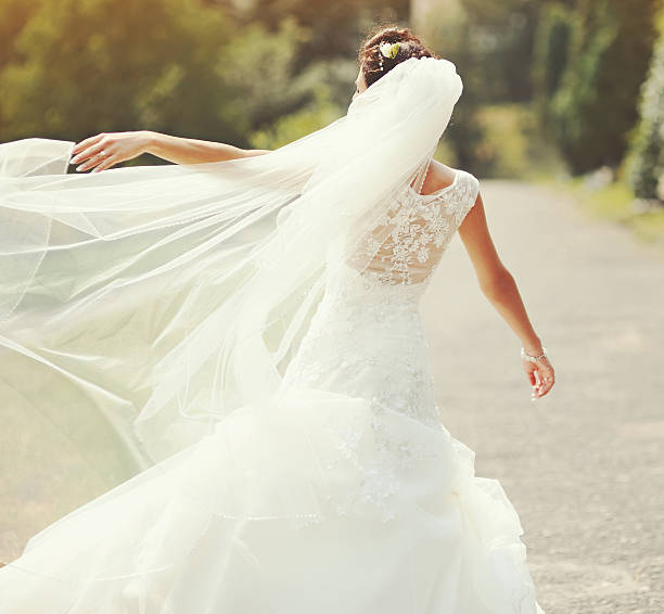 istock happy brunette bride spinning around with veil 187693327