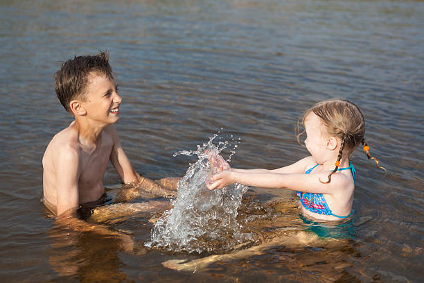 Men splashing and playing in a lake during summer vacation, enjoying the refreshing water