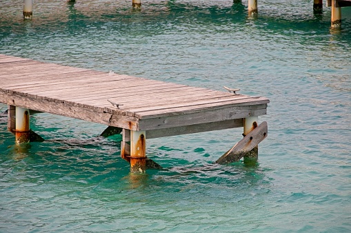 View of the horizon in the Mediterranean Sea. Wooden bridge, blue and light turquoise water. Mallorca, Balearic Islands. Sunny day and clear sky.