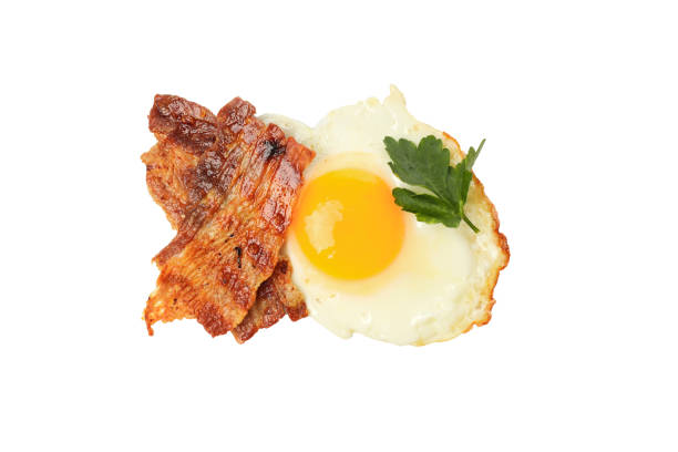 Breakfast with bacon , fried egg, coffee and vegetables