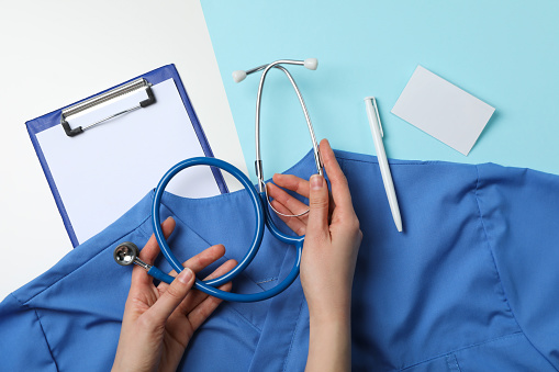 Stethoscope with blue medical coat and notebook