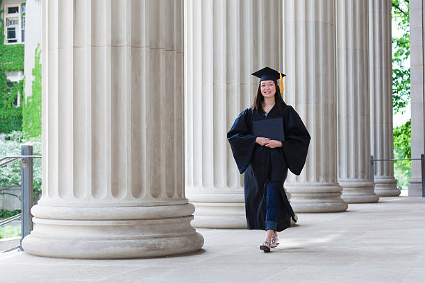 istock Happy Graduating Young Woman Student Walking on College Campus 187698418