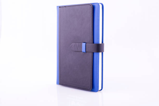 istock Blue notebook for writing business events on a white reflective background. 1877002374