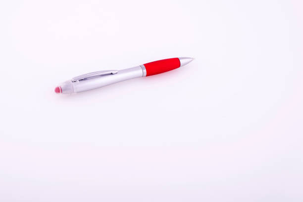 istock Red ballpoint pen on a reflective white background. 1877002380