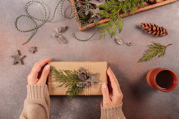 istock Christmas decor and Womans hands decorating handmade gift box 1877009634