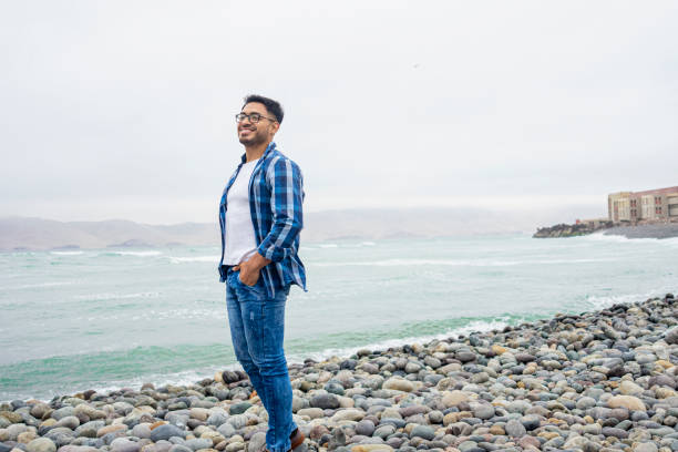 istock Young Peruvian man enjoying the sights while standing on the beach in Playa del Callao, Mirador de la Punta, Peru 1877017154