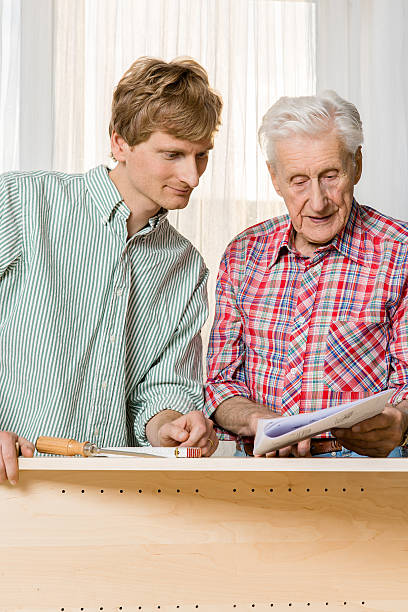 istock Collaboration: Grandfather and grandson assembling furniture 187701860