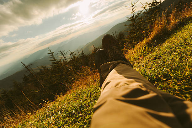 Man laying on the ground in a grass field. 