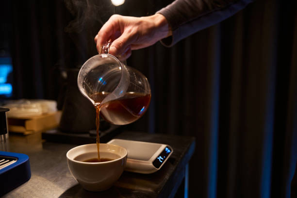 istock Faceless bartender pouring hot tasty from coffee maker into glass cup 1877035057