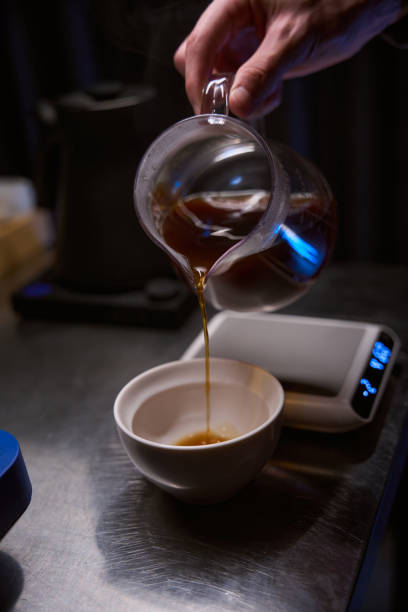 istock Bartender pouring hot aromatic from coffee maker into glass cup in coffee house 1877035653
