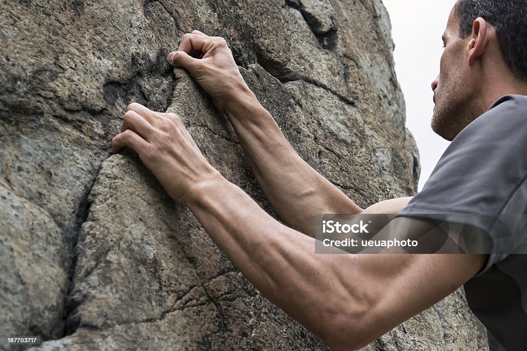 climber closeup arms of man climbing on rock Adrenaline Stock Photo