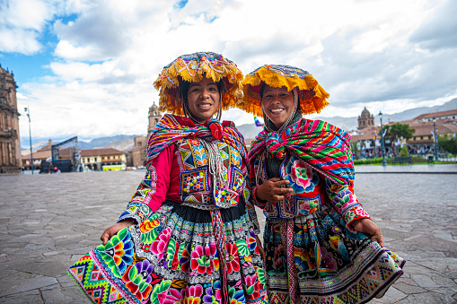 VALLADOLID, MEXICO - 21 MARCH 2013:  Smiling young women wearing an embroidered poncho are dancing a folk dance on streets of Mexican cities on March 21, 2013