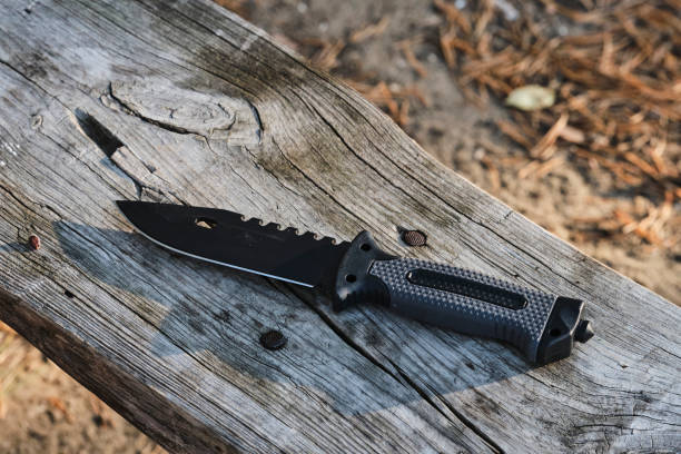 istock Tactical knife on a wooden background. 1877067141
