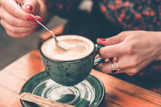 istock A young woman holds a coffee spoon and stirs hot coffee. 1877074976